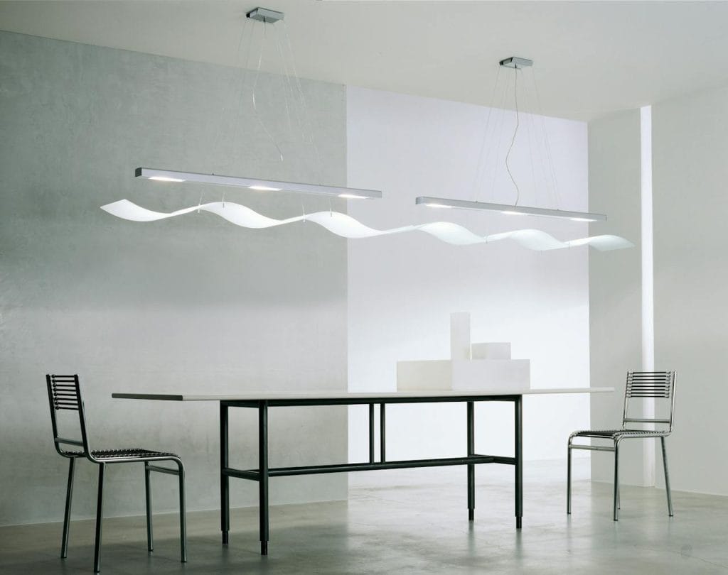 rectangular-glass-top-table-with-black-metal-base-and-several-chairs-near-wall-269252 A contemporary minimalist room with sleek furniture, modern lighting, and clean design.